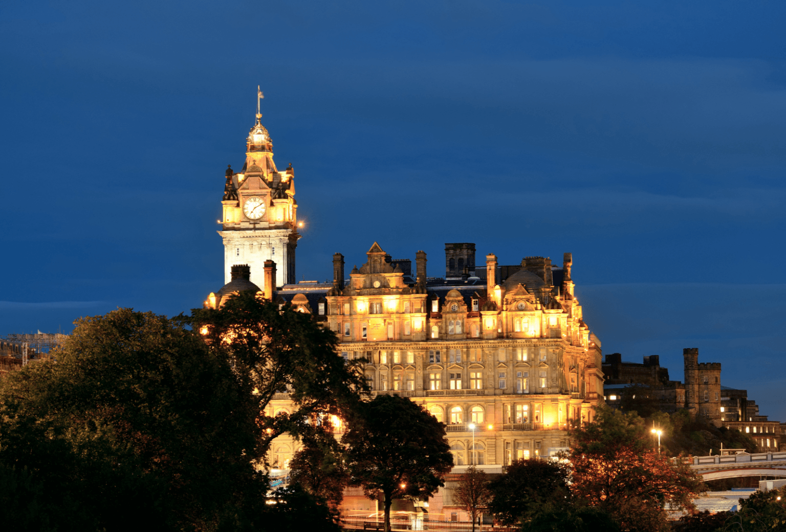 Drone photograph of a historic illuminated building at blue hour